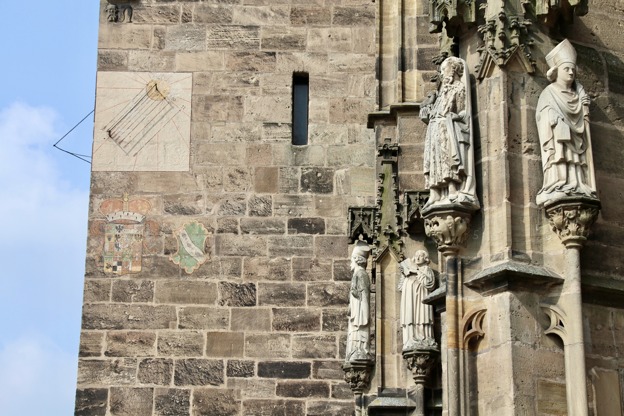 Sonnenuhr am Südturm mit dem Wappen der Ansbacher Marktgrafen und der Stadt Ansbach. Über der Sonnenuhr: Baumeistermaske. Foto: Hans-Martin Goede